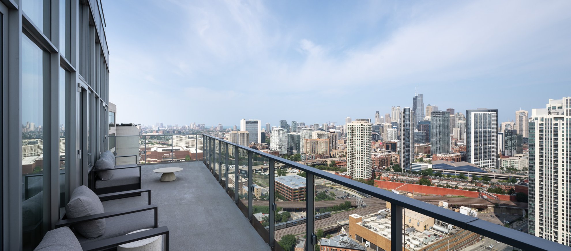 balcony with different seating area looking over chicago city view at the penthouse level chicago fulton market