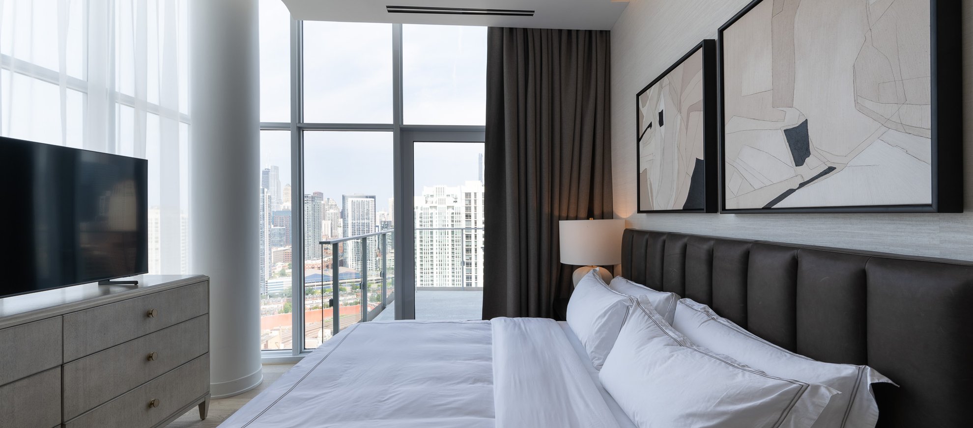 bedroom at the penthouse at level chicago fulton market features premium linen king bed and tv with spacious balcony looking over chicago city view