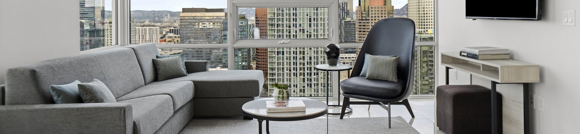 living room with a view of the LA skyline in a two bedroom suite at Level Los Angeles South Olive