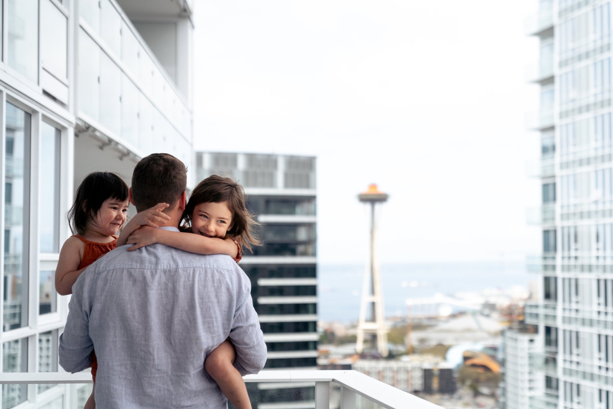 father holding daughters at level seattle south lake union