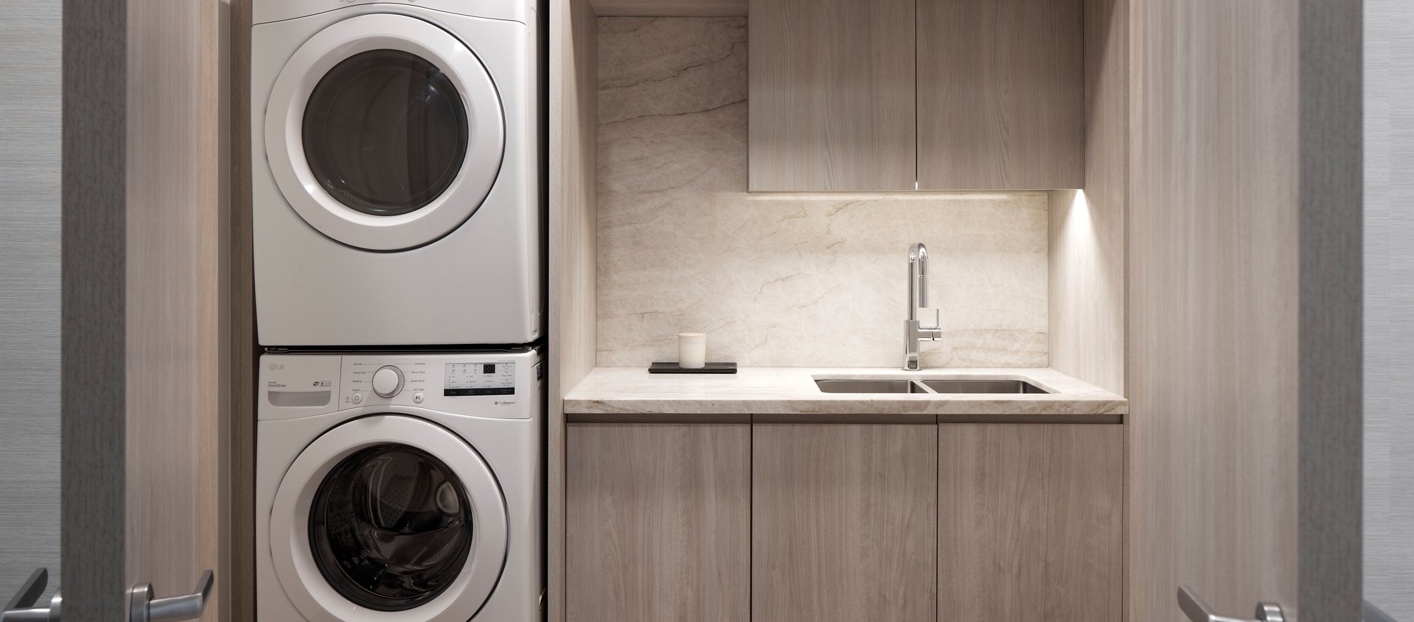 laundry room with a sink and stackable washer dryer at level seattle south lake union the penthouse.jpg