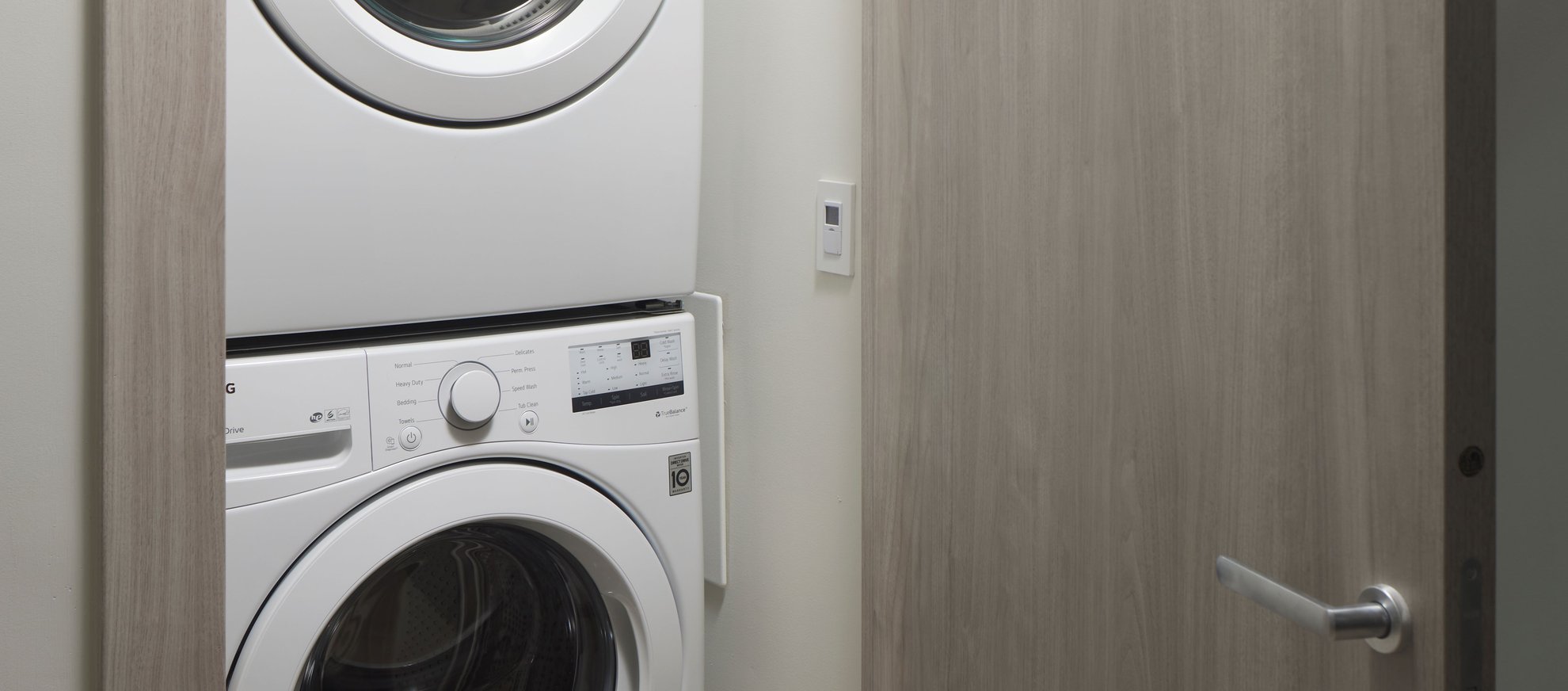 small laundry room with stackable washer dryer machine at level seattle south lake union the penthouse.jpg