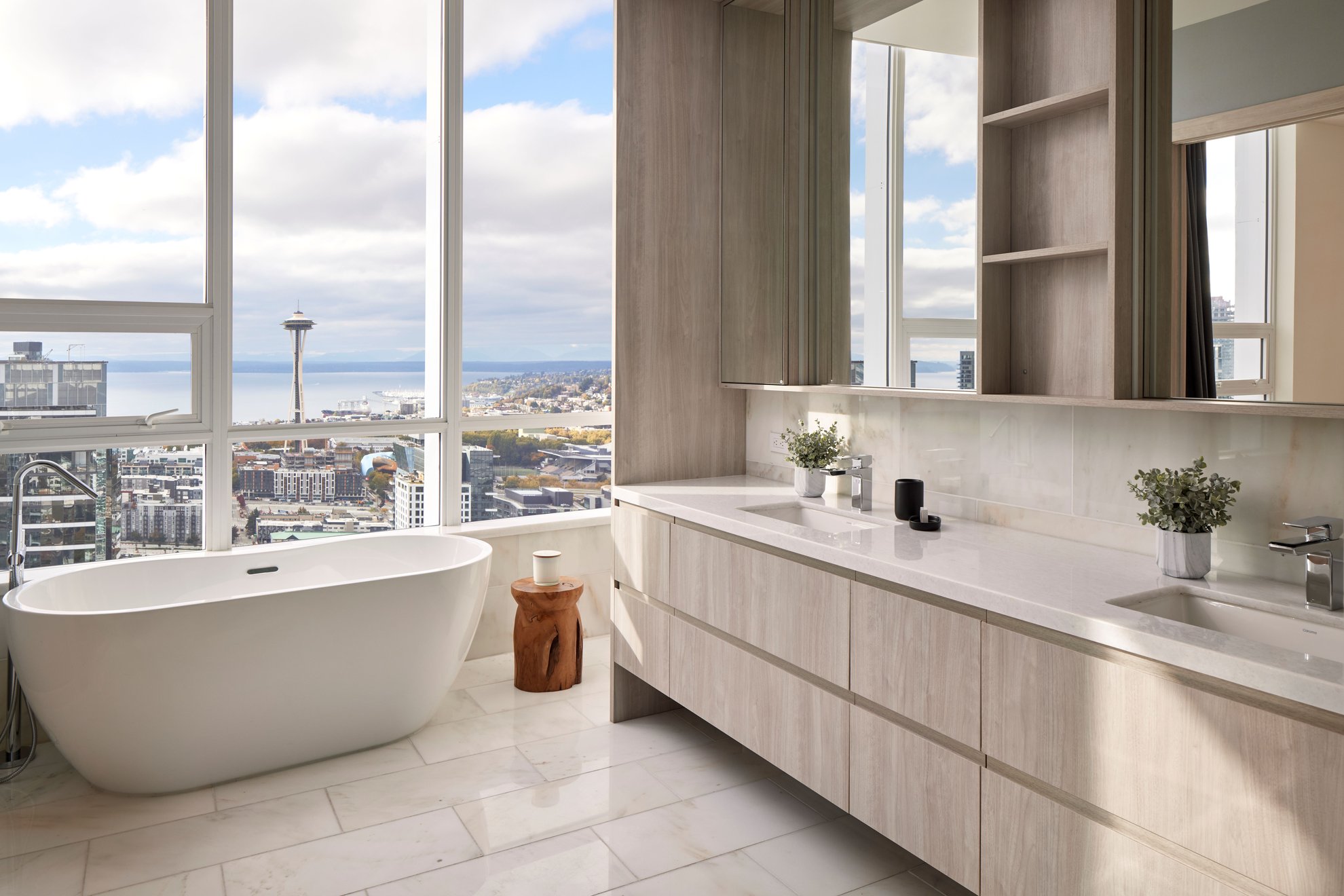 spacious elegant bathroom features white bathtub near large window with space needle seattle city view at level seattle south lake union the penthouse.jpg