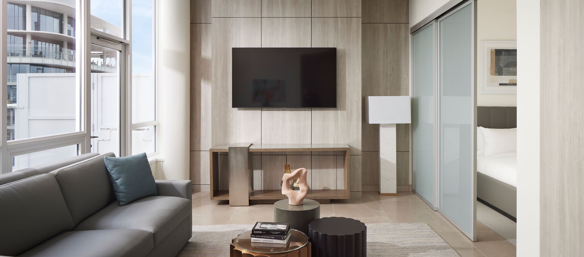 spacious modern living room connecting to bedroom with large windows, l shaped sofa at the penthouse level seattle south lake union.jpg